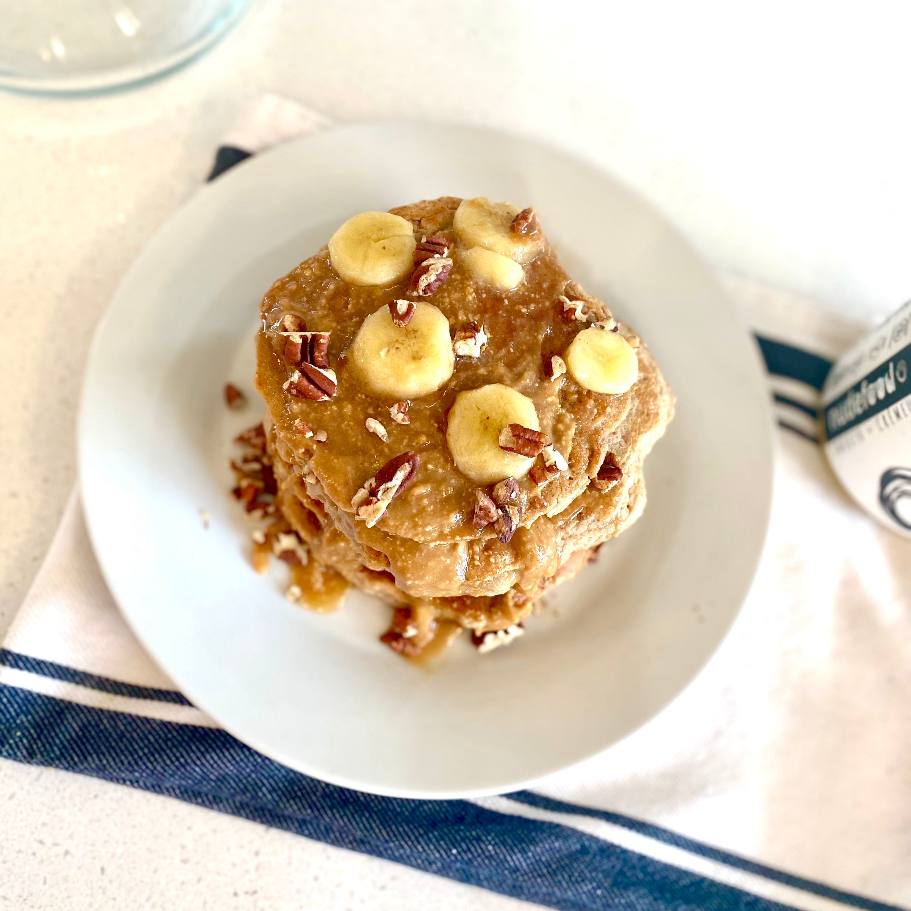 Stack of vegan gluten free protein banana pancakes with peanut butter syrup.